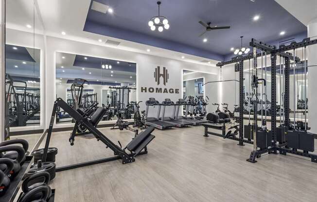 A gym with a variety of equipment including weights and cardio machines.