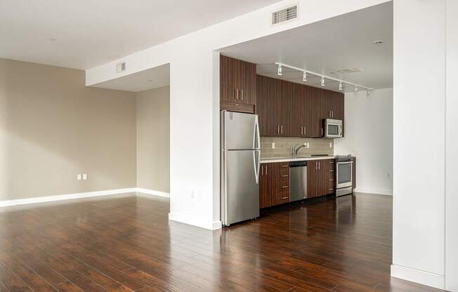 A kitchen with wooden cabinets and a refrigerator.