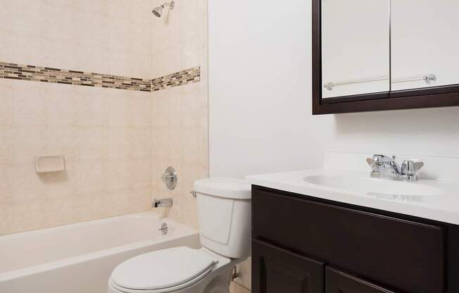 A white toilet sits next to a bathtub in a bathroom.