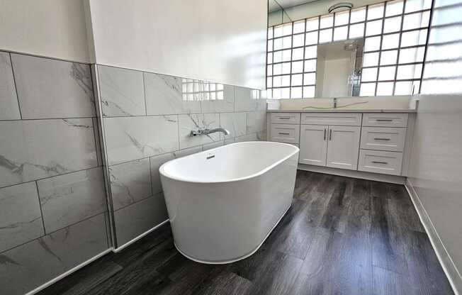 a white bathroom with a soaking tub and a sink