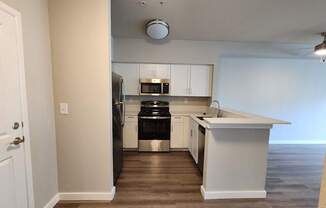 A kitchen with white cabinets and a black dishwasher.