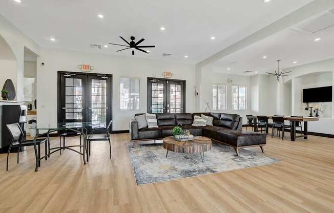 A living room with a black leather couch and a coffee table.