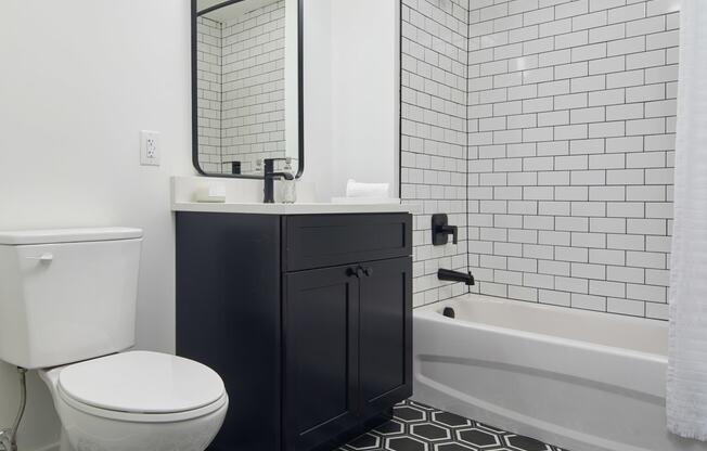 a black and white bathroom with a toilet and a shower