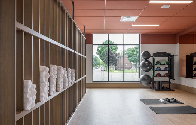 A gym with a row of shelves on the wall and exercise equipment.