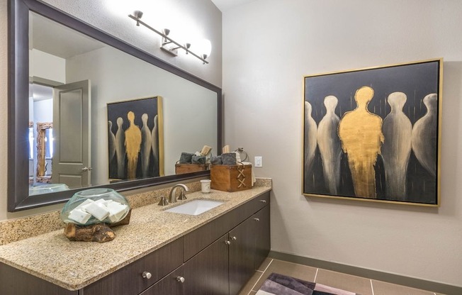Granite counters, custom-framed mirrors and tile floors in luxury bathrooms