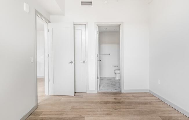 an empty room with white walls and doors to a bathroom at The Commonwealth Building, Pittsburgh, 15222