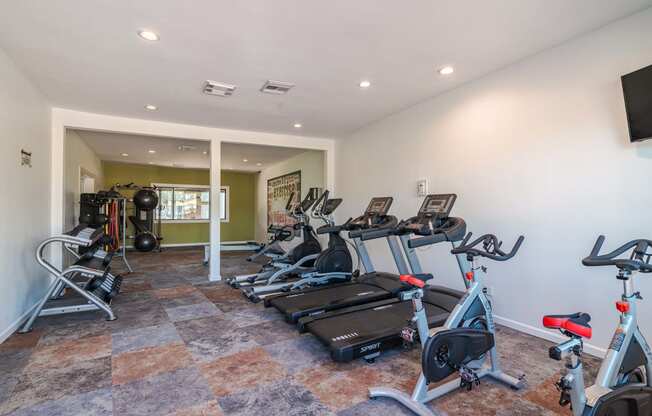 fitness center at Fusion Fort Worth apartments (previously Desert Sands) with cardio machines and large window