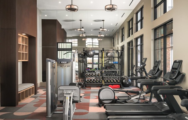 A gym with treadmills, elliptical machines, and other exercise equipment.