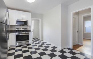 a kitchen with a checkered floor and stainless steel appliances