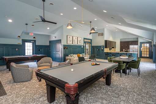 A room with a pool table and a ceiling fan.