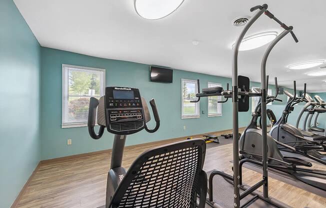 a gym with various machines and a light on the ceiling