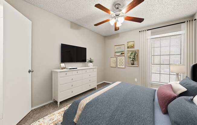 a bedroom with a bed and a ceiling fan