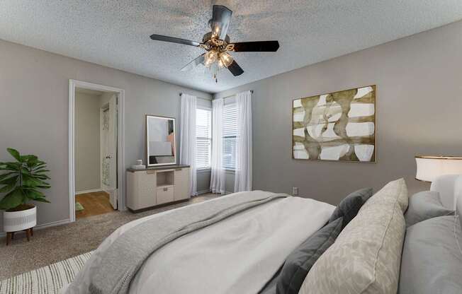 A bedroom with a large bed and a ceiling fan.