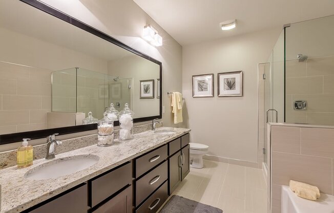 Bathrooms with dual vanities, framed mirrors and granite countertops