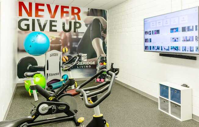 a workout room with weights and a motivational poster on the wall