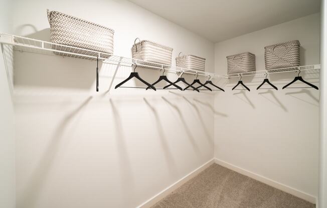 a spacious closet with shelves and hangers with chairs