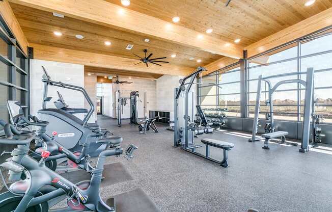 A gym with a variety of exercise equipment including treadmills, stationary bikes, and weight machines.