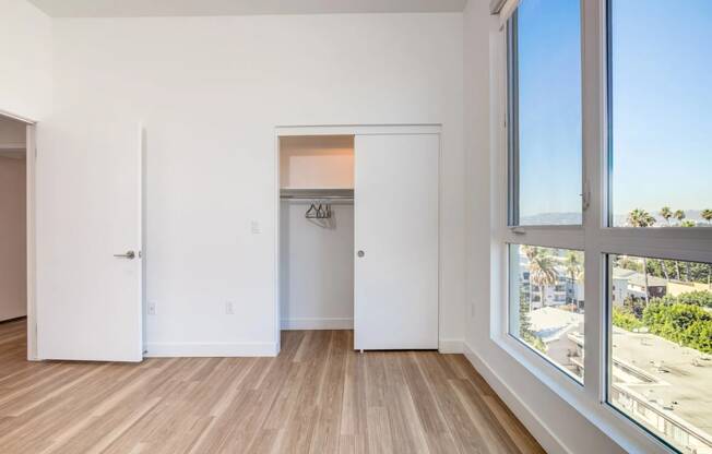 a living room with a large window and a door to a closet