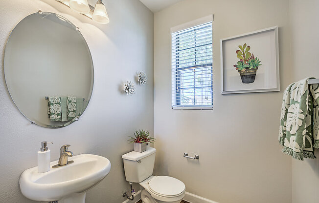 Refresh in style at The Michael B's updated guest bathroom, featuring a crisp white sink and toilet bathed in natural light.at The Michael B Townhomes and Flats, Las Vegas, NV