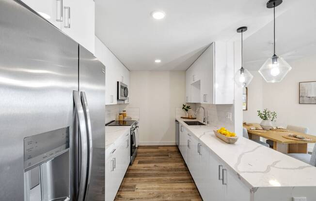 a kitchen with white cabinets and stainless steel appliances