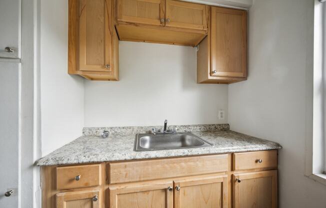 A kitchen with wooden cabinets and a granite countertop.