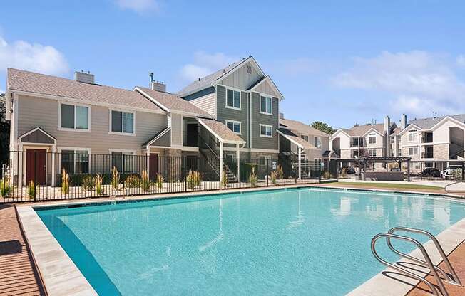 Community Swimming Pool with Pool Furniture at Broadmoor Village Apartments located in West Jordan, UT.