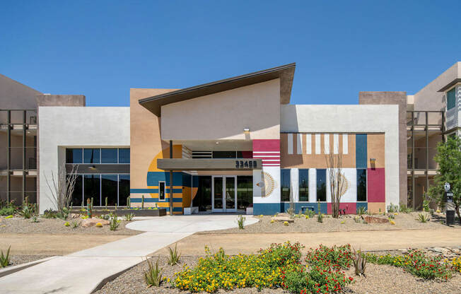 A modern building with a colorful facade and a clear blue sky in the background.