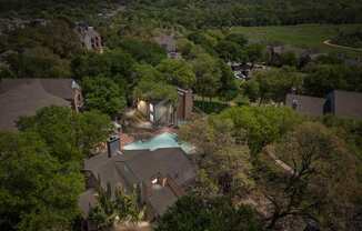 A house with a pool surrounded by trees. at Montecito, Texas, 78741