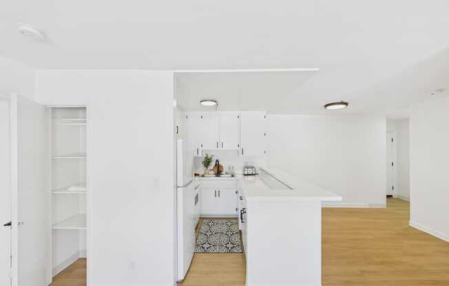 A kitchen with white cabinets and a white island.
