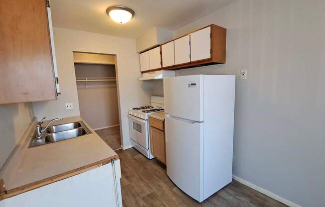 A small kitchen with a sink, stove, and refrigerator.