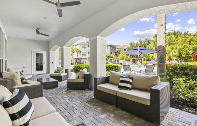 an outdoor patio with couches and chairs and umbrellas