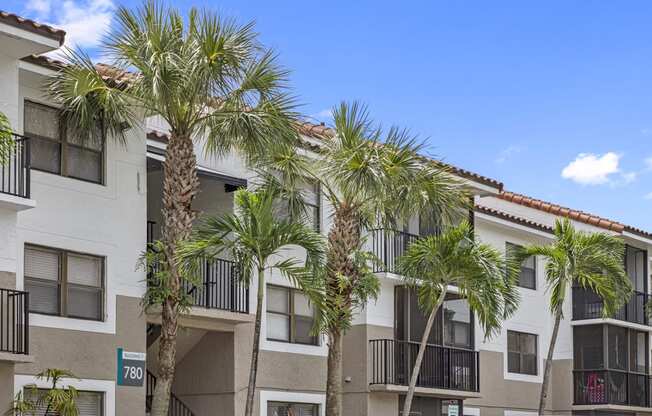 a picture of an apartment building with palm trees in front of it