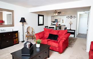 a living room with a red couch and a black coffee table