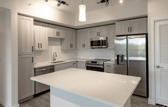 a kitchen with a large island and stainless steel appliances