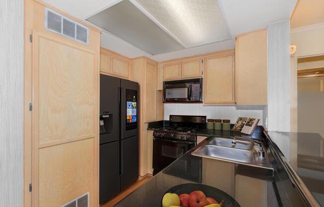 a large kitchen with stainless steel appliances and wooden cabinets