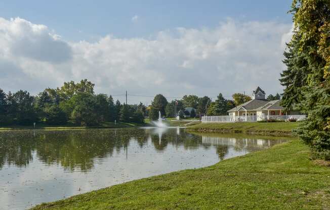 a view of a pond with a house on the other side of it