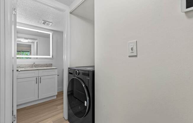 A washing machine is placed in a laundry room.
