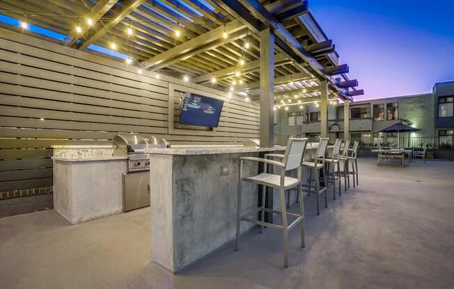 a patio with a bar and tables with chairs