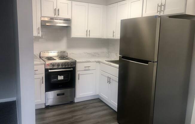 a kitchen with white cabinets and stainless steel appliances