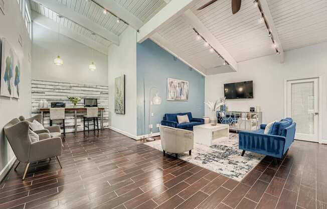 A living room with a blue couch and a dining table.