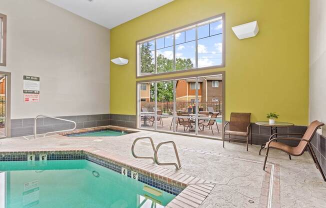A swimming pool inside a building with a yellow wall.