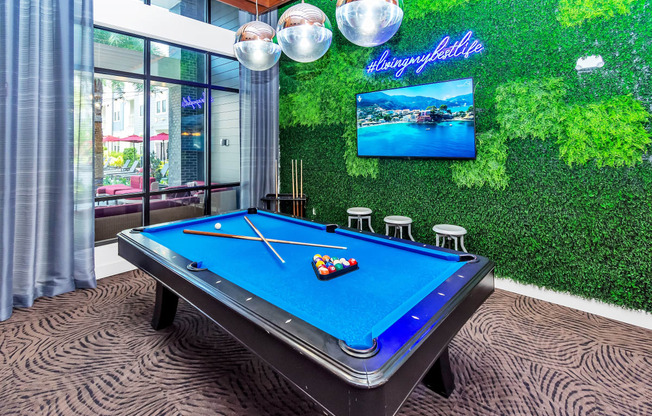 a pool table with a tv on the wall