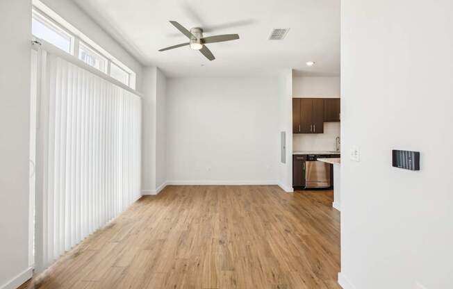 A room with a ceiling fan and wooden flooring.