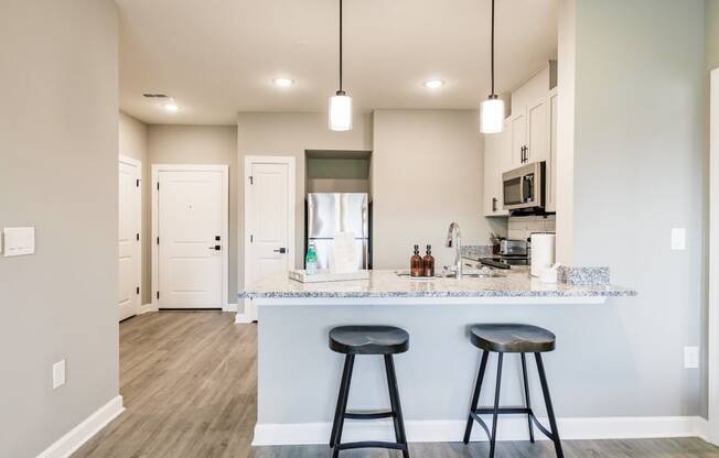bar stools at a kitchen bar with a refrigerator in the background