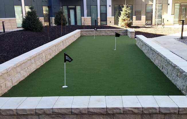 Outdoor putting green with three holes with small flags in them