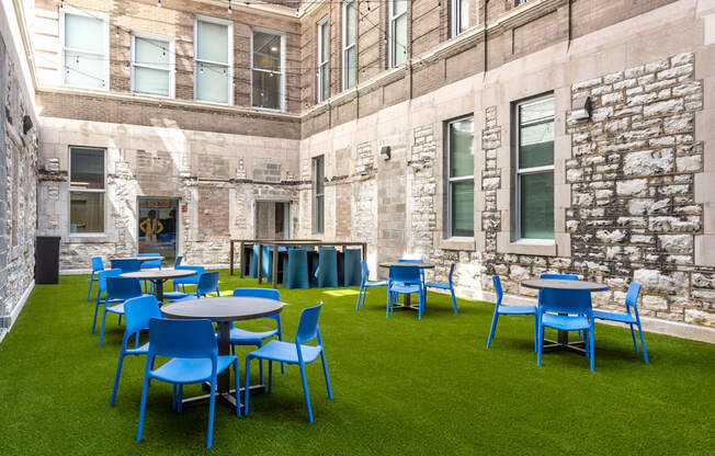 A patio with blue chairs and tables.