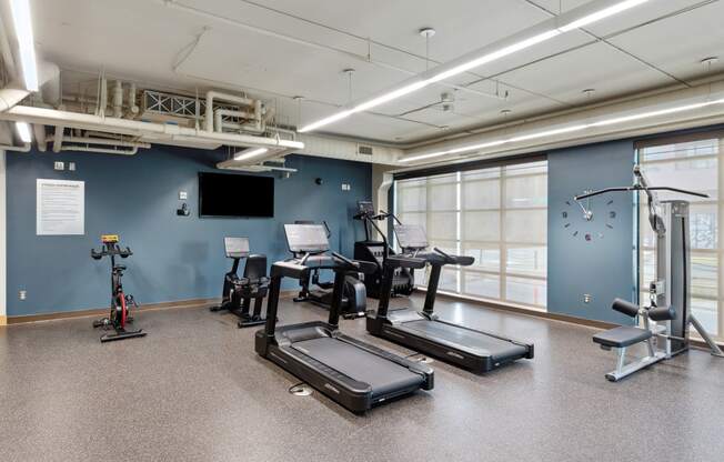 a workout room with treadmills and other exercise equipment