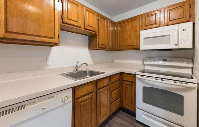 A kitchen with wooden cabinets and white appliances.