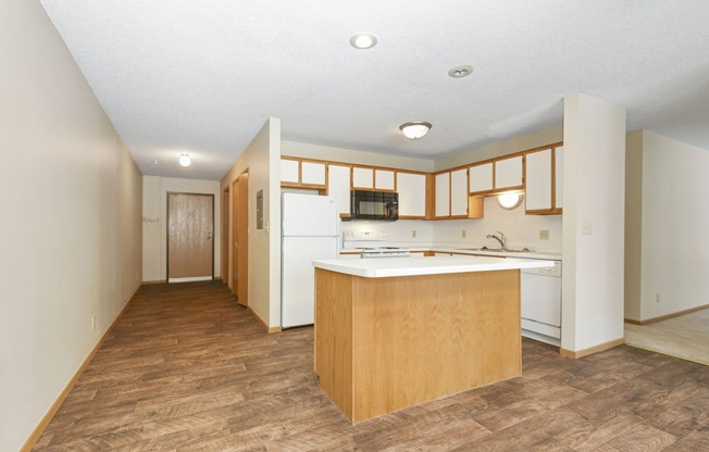 Anoka, MN Dellwood Estates Apartments. a kitchen with white appliances and wooden cabinets