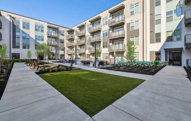 an exterior view of an apartment building with a sidewalk and grass at Link Apartments® Broad Ave, Memphis, 38112
